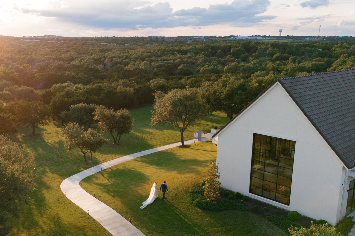 Couple walking The Arlo grounds at sunset with the Texas Hill Country in the distance